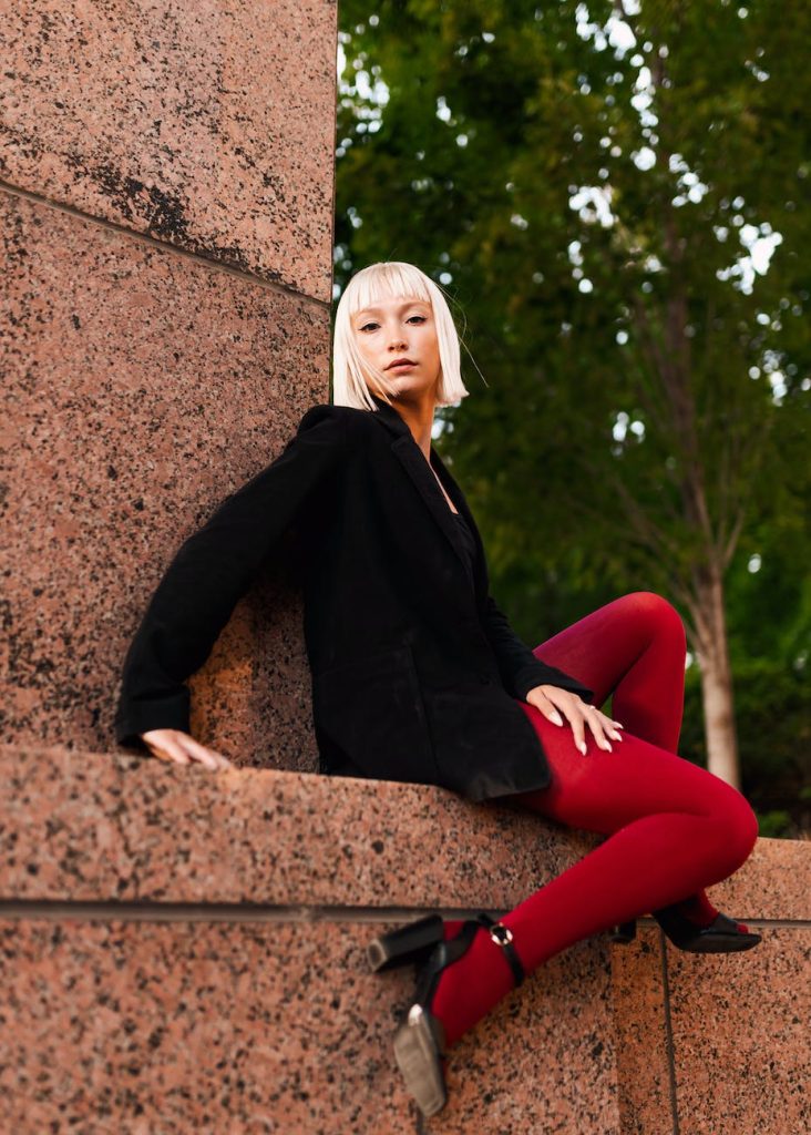 blonde fashion girl in red tights and black jacket